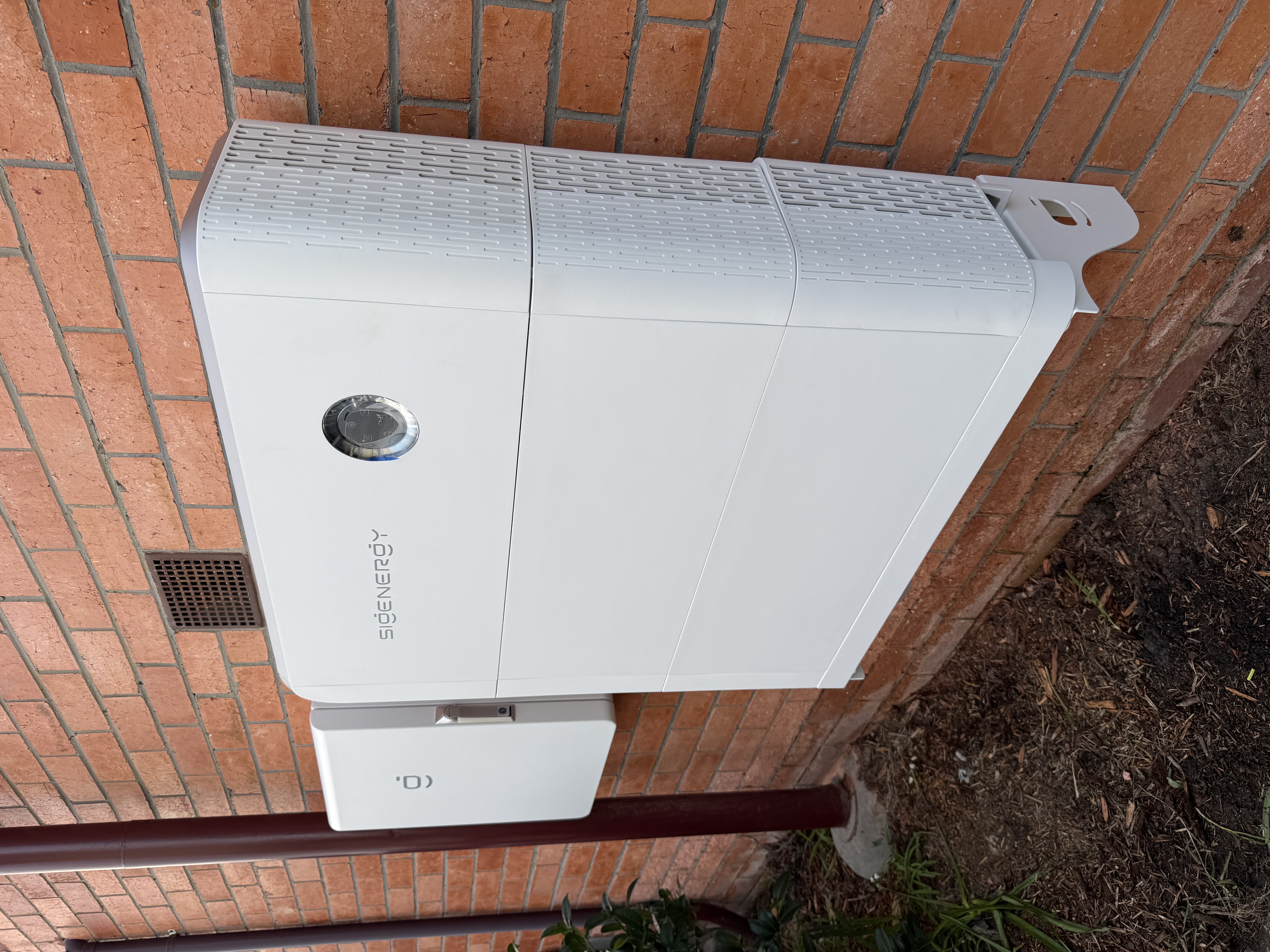 SigenEnergy battery storage with gateway unit on brick wall